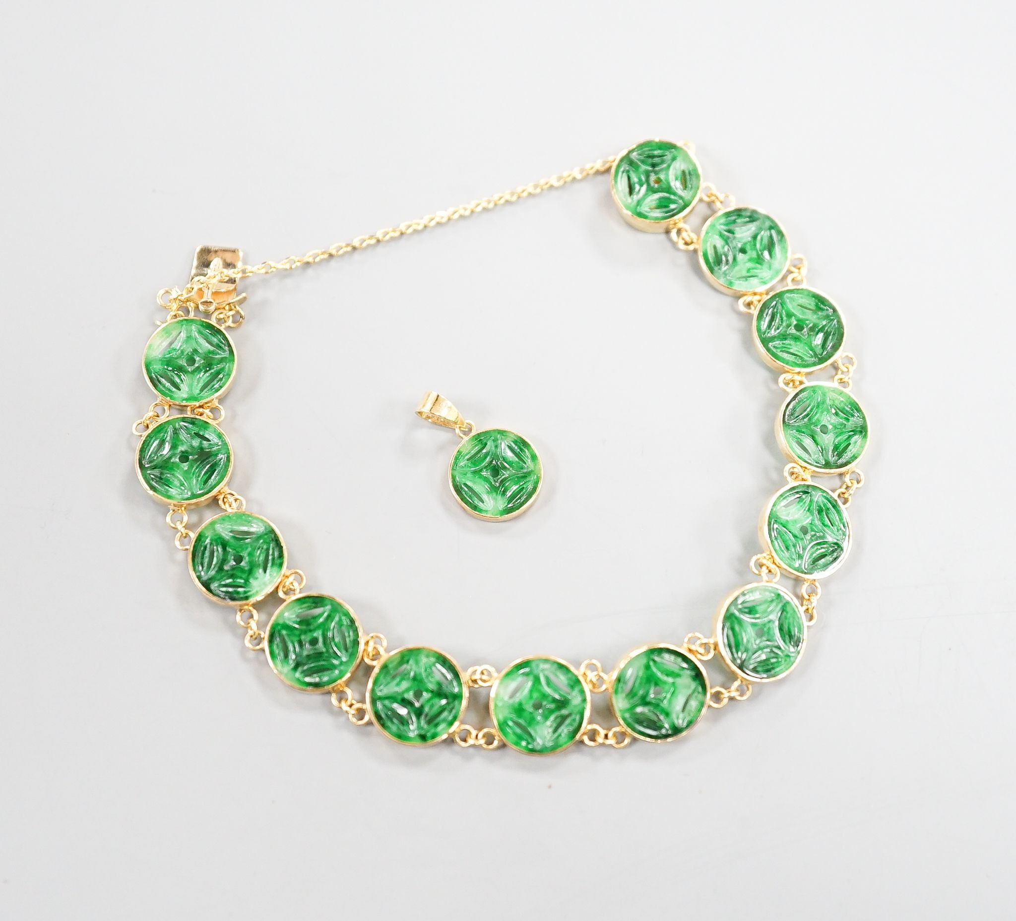 A Chinese 850 yellow metal and jade disc bracelet, 15cm and a matching small pendant, gross 9.7 grams.